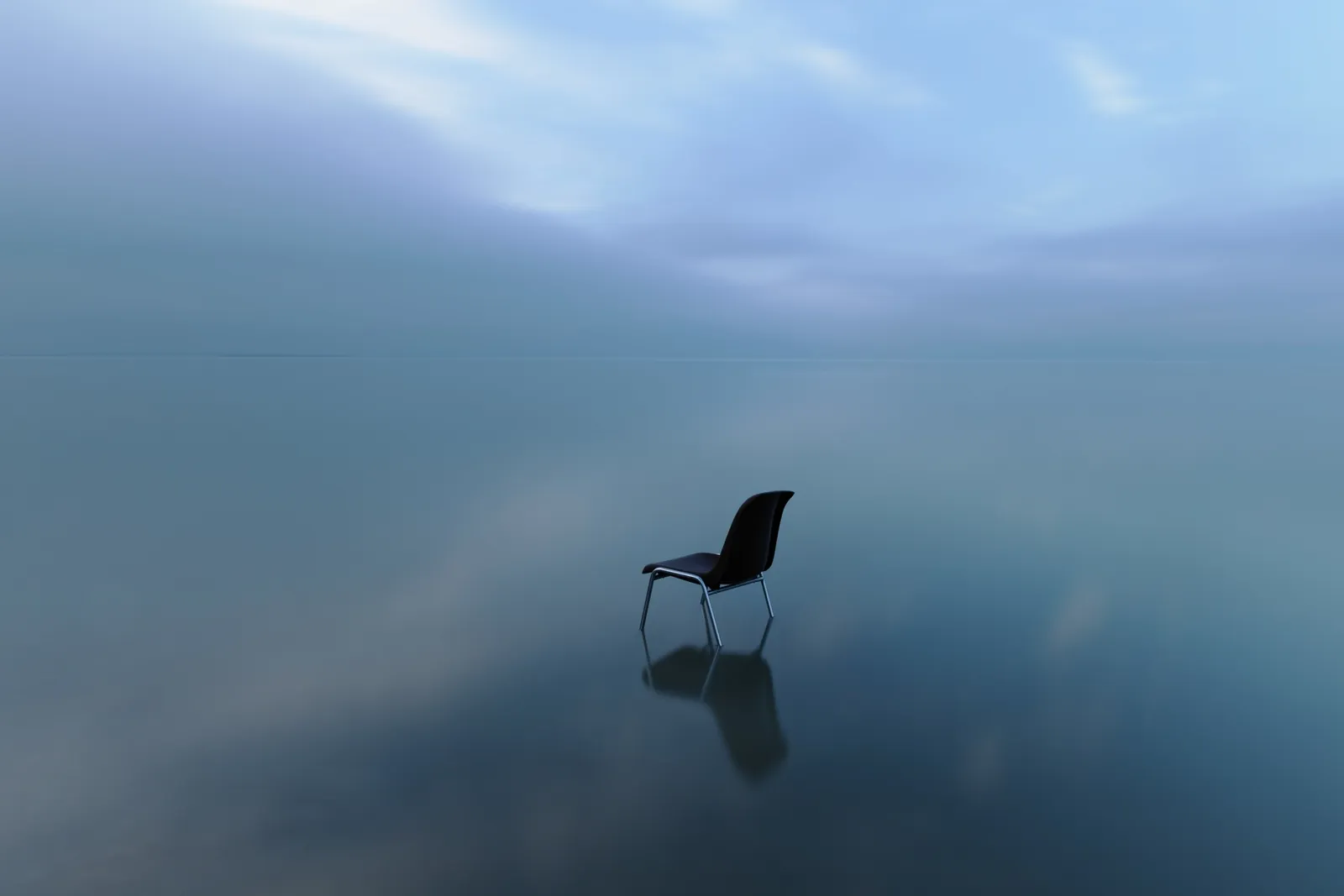 A single chair standing on still water